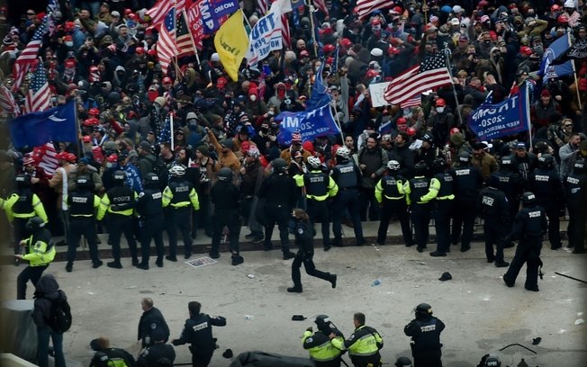 Polícia tenta conter apoiadores do ex-presidente americano Donald Trump, em frente ao Capitólio, em 6 de janeiro de 2021