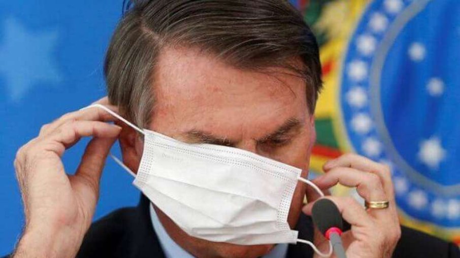 Bolsonaro colocando a máscara 