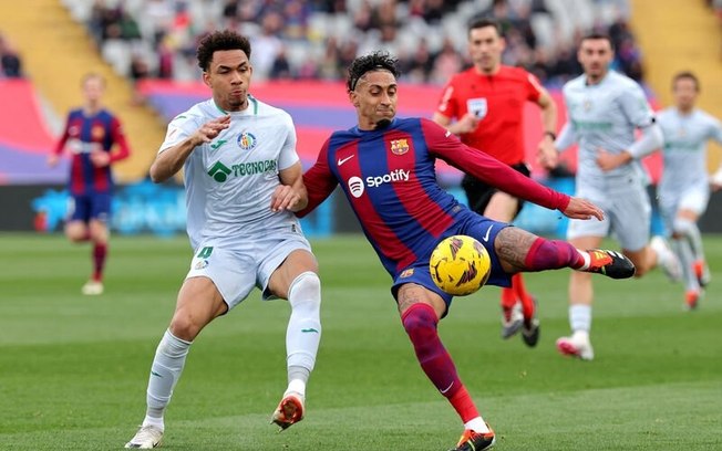 Raphinha em disputa de bola com jogador do Getafe - Foto: Lluis Gene/AFP via Getty Images