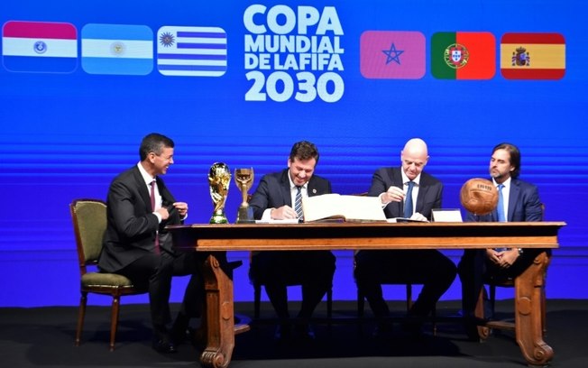 O presidente da Conmebol, Alejandro Domínguez (segundo à esquerda), eo presidente da Fifa, Gianni Infantino (terceiro à equerda), assinam o compromisso do Mundial de 2030 em abril deste ano, no Paraguai