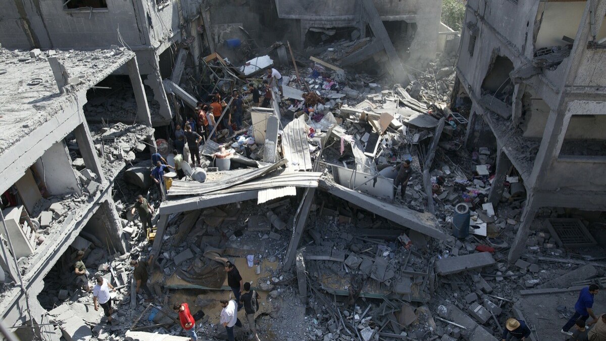 Bombeiros, juntamente com o pessoal da defesa civil e médicos na cidade de Gaza e outros membros da comunidade unem forças para limpar os escombros de uma casa atingida pelas forças israelitas na área de Al Remal