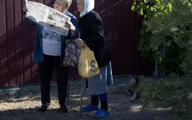 Moradores de Liman, no leste da Ucrânia, leem a última edição do jornal local Zoria em 19 de setembro de 2024