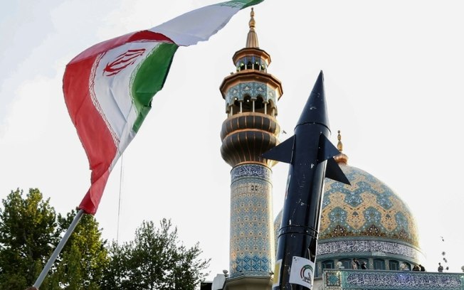 Uma bandeira iraniana e uma réplica de um míssil, exibidas durante a celebração do ataque com mísseis e drones contra Israel, em 15 de abril de 2024, na Praça Palestina, em Teerã
