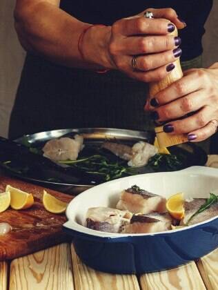 pessoa temperando peixe