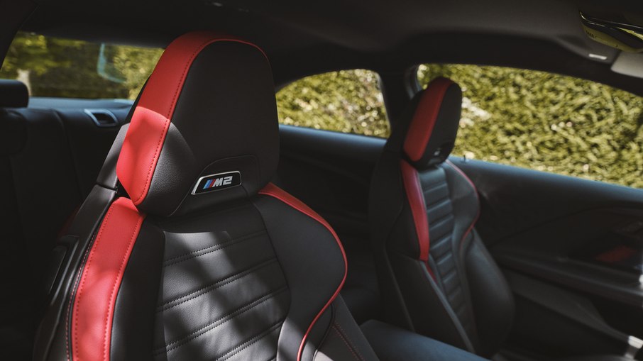 Interior do BMW M2 oferece bancos esportivos com bom apoio e acabamento com detalhes em vermelho