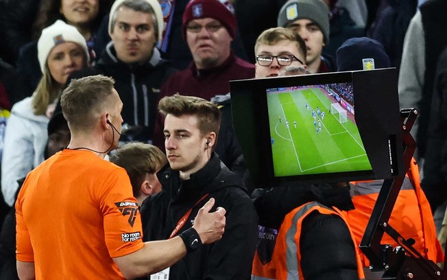 Árbitro Craig Pawson observa monitor do VAR durante partida entre Chelsea e Aston Villa - Foto: Darren Staples/AFP via Getty Images