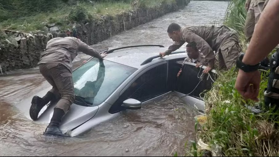 Agentes da PM em cima do carro para salvar idoso, em MG