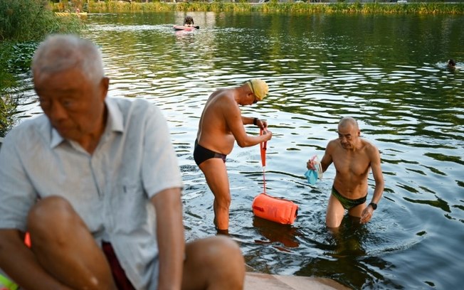 Idosos chineses se banham no rio Liangma durante as festas de Meio Outono em Pequim, em 16 de setembro de 2024