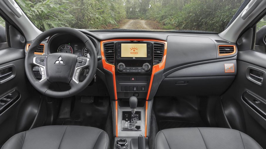 Interior com detalhes em laranja é tradição das versões Sertões da Mitsubishi 