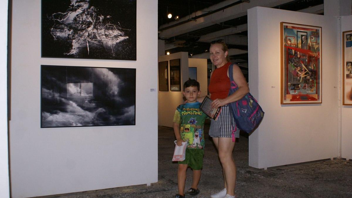 Liliane e o filho Lucas durante visita à exposição