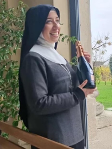 foto de freira sorrindo enquanto segura flores