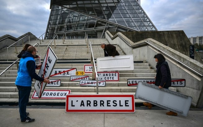 Agricultores irritados exibem sinais de trânsito, tirados das aldeias e cidades vizinhas, nas escadas do Musée des Confluences para aumentar a visibilidade como parte de um protesto nacional contra o acordo UE-Mercosul em Lyon em 18 de novembro de 2024