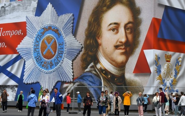 Turistas na Praça Dvortsovaya, em São Petersburgo, em frente a um mural representando Pedro, o Grande, o fundador da cidade, em 9 de junho de 2024