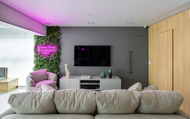 Jardim vertical de avencas com neon personalizado dá energia alegre para este apê