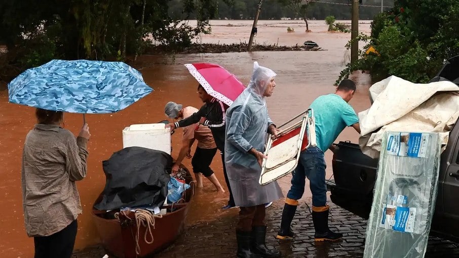 Moradores do estado do Rio Grande do Sul retirando seu objetos da área alagada