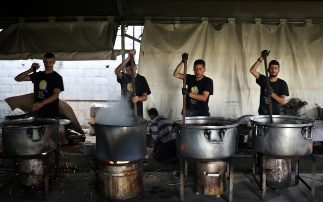 Voluntários locais do World Central Kitchen preparam refeições para serem distribuídas aos palestinos necessitados em Rafah, no sul da Faixa de Gaza, em 3 de maio de 2024, em meio ao conflito em curso entre Israel e o movimento Hamas