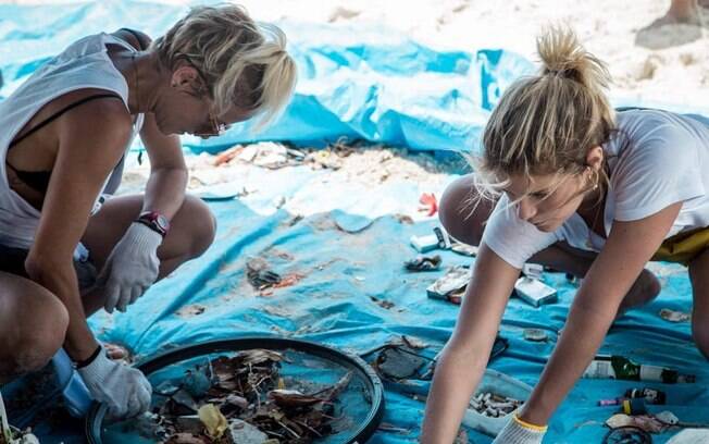 Isabella Santoni e Fernanda de Freitas recolhem lixo de praia carioca.