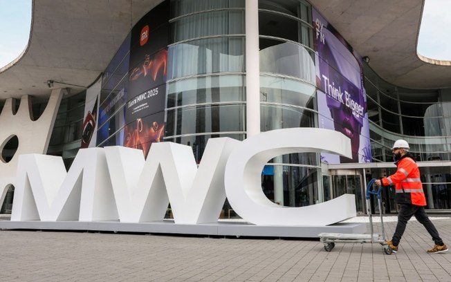 Um trabalhador passa pela entrada da Feira Barcelona, onde se realiza o Mobile World Congress (MWC), o maior evento de conetividade do mundo, em Barcelona, em 27 de fevereiro de 2025 Um trabalhador passa pela entrada da Feira Barcelona, onde se realiza o Mobile World Congress (MWC), o maior evento de conetividade do mundo, em Barcelona, em 27 de fevereiro de 2025