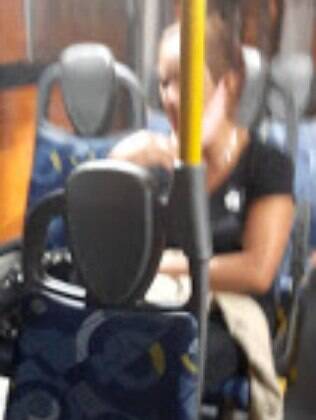 Passageira com a máscara sob o queixo no ônibus