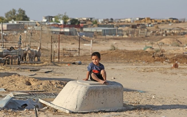 Uma criança brinca na aldeia beduína de Ras Jrabah, a leste da cidade de Dimona, sul de Israel, em 29 de maio de 2024