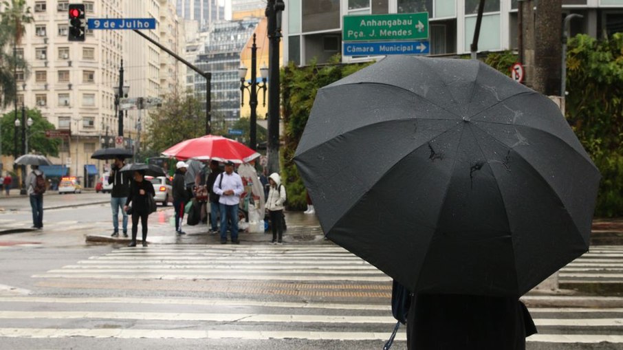 Pedestres se protegem da chuva no centro da capital paulista