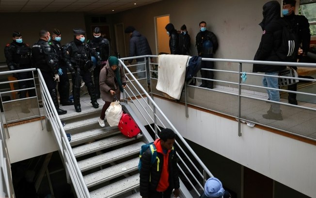 Gendarmes franceses supervisionam a expulsão de migrantes de uma fábrica abandonada em Vitry-sur-Seine, ao sul de Paris, em 17 de abril de 2024