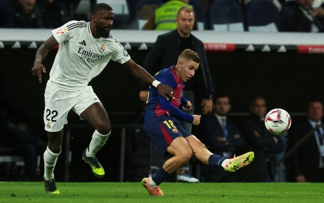Fermín López (D) recebe a marcação de Antonio Rüdiger durante clássico entre Barcelona e Real Madrid pelo Campeonato Espanhol Fermín López (D) recebe a marcação de Antonio Rüdiger durante clássico entre Barcelona e Real Madrid pelo Campeonato Espanhol