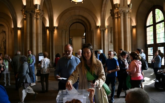 Mulher deposita seu voto na urna de uma seção eleitoral na Universidade de Barcelona, em 12 de maio de 2024