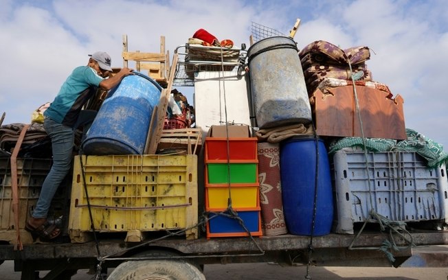 Palestinos deslocados carregam seus pertences em um caminhão antes de deixar Rafah, no sul da Faixa de Gaza, em 20 de junho de 2024