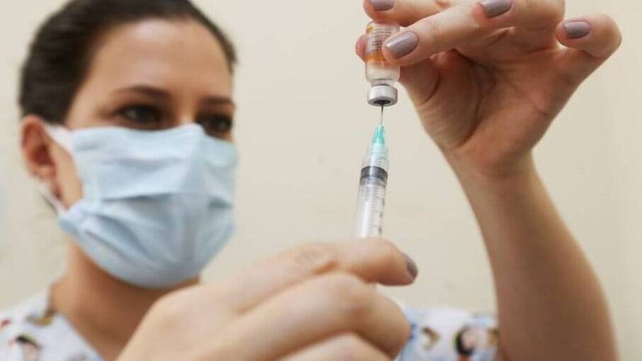 Enfermeira enchendo seringa com vacina contra a Covid-19