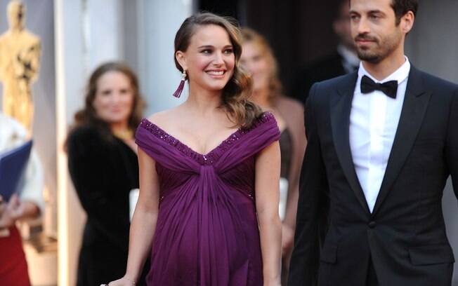 Natalie Portman exibindo barrigão durante cerimônia do Oscar ao lado de seu marido