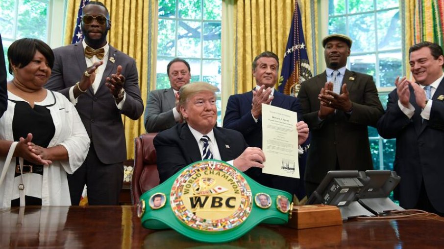 O presidente Donald Trump concedeu um perdão póstumo a Jack Johnson na quinta-feira. Trump aparece acompanhado, da esquerda para a direita, por Linda Haywood, que é sua trineta, pelo campeão dos pesos-pesados Deontay Wilder, Keith Frankel, Sylvester Stallone, o ex-campeão dos pesos-pesados Lennox Lewis e o presidente do Conselho Mundial de Boxe, Mauricio Sulaimán. O presidente Donald Trump concedeu um perdão póstumo a Jack Johnson na quinta-feira. Trump aparece acompanhado, da esquerda para a direita, por Linda Haywood, que é sua trineta, pelo campeão dos pesos-pesados Deontay Wilder, Keith Frankel, Sylvester Stallone, o ex-campeão dos pesos-pesados Lennox Lewis e o presidente do Conselho Mundial de Boxe, Mauricio Sulaimán.