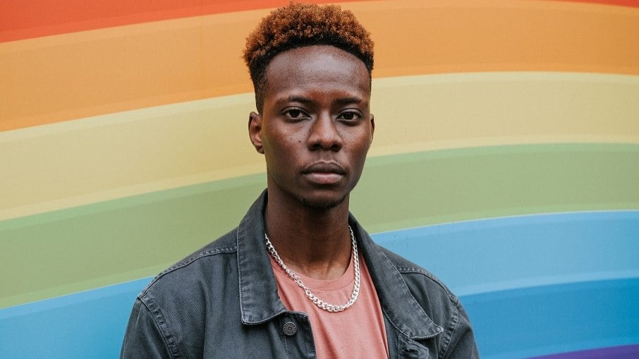 Homem gay negro com arco-íris ao fundo