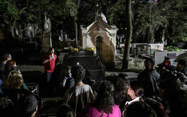 Visitantes ouvem o advogado Thiago de Souza (centro, em vermelho) durante visita noturna ao cemitério da Consolação, em São Paulo Visitantes ouvem o advogado Thiago de Souza (centro, em vermelho) durante visita noturna ao cemitério da Consolação, em São Paulo