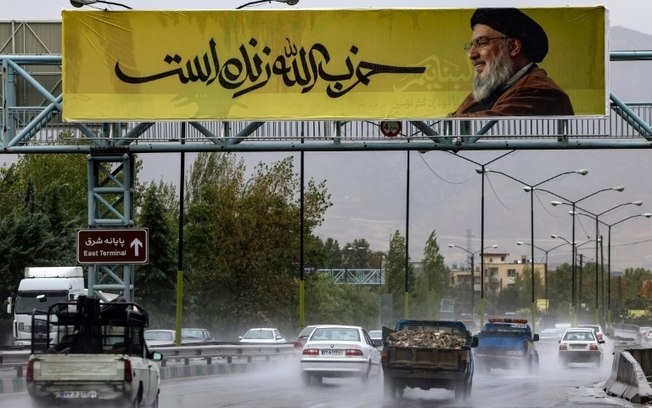 Faixa com a imagem do líder do movimento libanês Hezbollah, Hassan Nasrallah, onde se lê “O Hezbollah vive', em uma ponte no norte de Teerã, em 28 de setembro de 2024