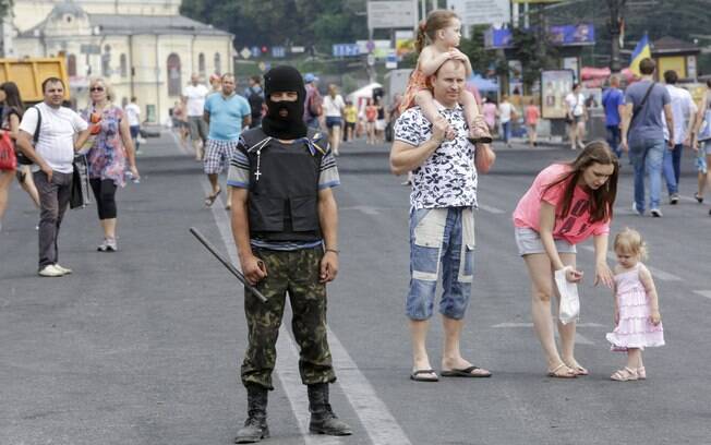 Manifestante ao lado de transeuntes na Praça da Independência em Kiev (9/08). Foto: Reuters