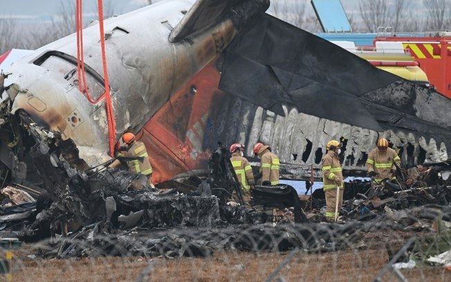 Bombeiros e equipes de resgate trabalham no local da queda de um avião no aeroporto da cidade sul-coreana de Muan, em 30 de dezembro de 2024