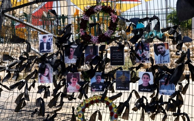 Fotos das crianças e dos jovens mortos no bombardeio de sábado foram penduradas no campo de futebol da aldeia drusa de Majdal Shams, nas Colinas de Golã, anexadas por Israel, em 29 de julho de 2024, em meio aos contínuos confrontos transfronteiriços entre tropas israelenses e combatentes do Hezbollah