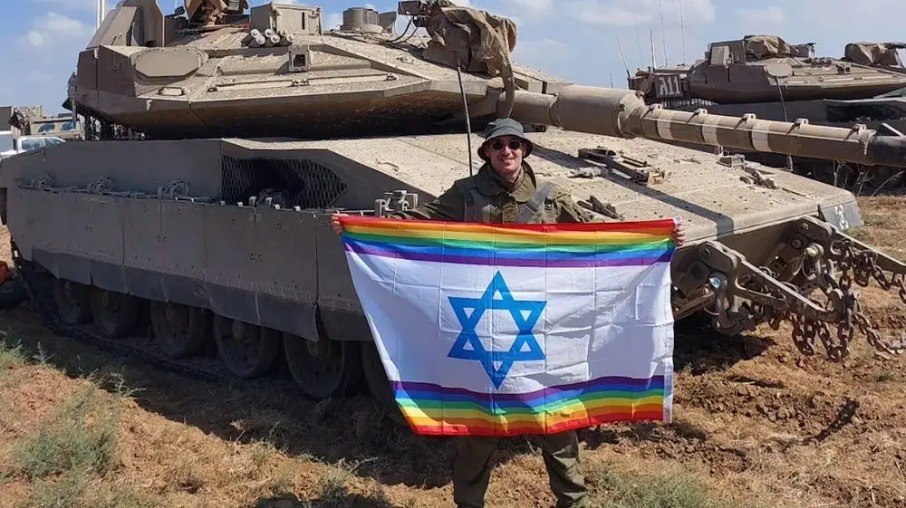 Um soldado israelense gay exibe com orgulho uma bandeira LGBTQ na Faixa de Gaza depois de trazer a bandeira do orgulho com ele para combater o Hamas