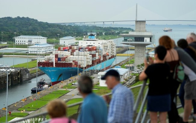 Turistas observam o cargueiro dinamarquês Lars Maersk navegar pelas eclusas de Agua Clara do Canal do Panamá, na cidade de Colón, Panamá, em 28 de dezembro de 2024