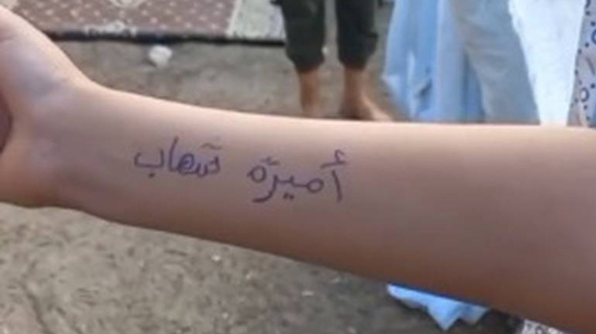 Criança palestina com nome escrito no braço 