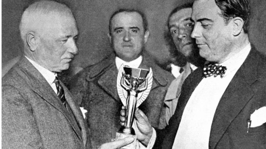 O presidente da FIFA, Jules Rimet (à esquerda), entregando a primeira taça da Copa do Mundo de 1930 para o então presidente da Associação Uruguaia de Futebol, Dr. Raul Jude. O torneio sediado e vencido pelo Uruguai marcou o início da história das Copas. O presidente da FIFA, Jules Rimet (à esquerda), entregando a primeira taça da Copa do Mundo de 1930 para o então presidente da Associação Uruguaia de Futebol, Dr. Raul Jude. O torneio sediado e vencido pelo Uruguai marcou o início da história das Copas.