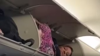 Mulher dorme em compartimento de bagagem de avião
