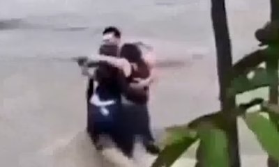 Três amigos se abraçam antes de serem levados por rio