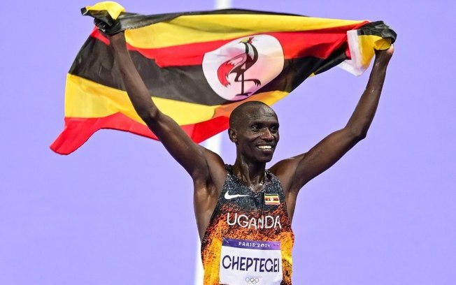 O ugandense Joshua Cheptegei comemora seu título olímpico nos 10.000m em 2 de agosto de 2024, no Stade de France, nos arredores de Paris