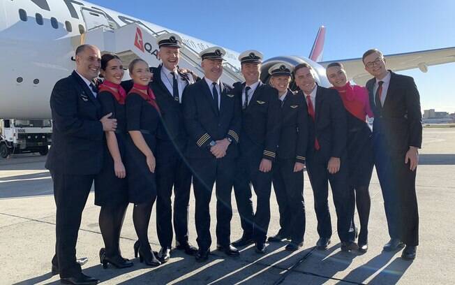 O voo mais longo do mundo%2C realizado pela Qantas%2C levou 19 horas e 16 minutos para ir de Nova York a Sydney Comissários de bordo e pilotos do voo mais longo do mundo em frente à aeronave no aeroporto