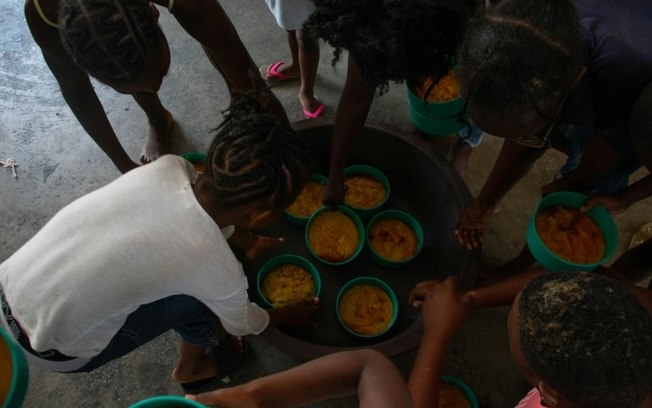 Crianças recebem refeições em escola de Porto Príncipe, Haiti, transformada em abrigo para os deslocados pela violência vinculada às gangues