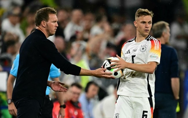 O técnico da Alemanha, Julian Nagelsmann (E), entrega a bola para Joshua Kimmich (D) durante jogo contra a Dinamarca pela Eurocopa O técnico da Alemanha, Julian Nagelsmann (E), entrega a bola para Joshua Kimmich (D) durante jogo contra a Dinamarca pela Eurocopa