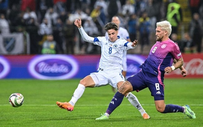 O meia da Bósnia e Herzegovina Denis Huseinbasic (à esquerda) disputa com o meia alemão Robert Andrich durante a partida da Liga das Nações no estádio Bilino Polje em Zenica, 11 de outubro de 2024