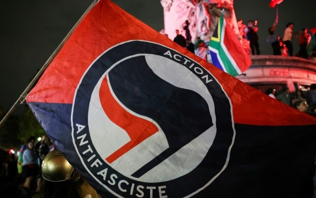 Uma bandeira antifascista é vista na Place de la Republique, em Paris, na noite de domingo, 7 de julho de 2024